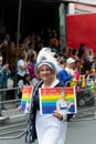 Vertical shot of an older female walking with banners at the pride parade in London