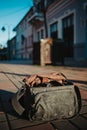 Vertical shot of an open camera bag on the cobblestone ground