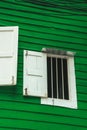 Vertical shot of open white windows on a green wall Royalty Free Stock Photo