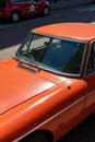 Vertical shot of an orange old car on the streets of Amsterdam, The Netherlands