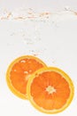 Vertical shot of orange slices bubbling in water