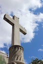 Vertical shot of an outdoor stone cross under a blue cloudy sky Royalty Free Stock Photo