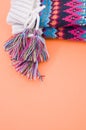 Vertical shot of a pair of colorful mittens on an orange surface