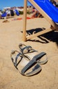 Vertical shot of a pair of sandals on the sand on a sunny day