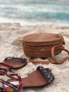 Vertical shot of a pair of sandals and a wicker bag on the sand of a beach in Nassau, Bahamas Royalty Free Stock Photo