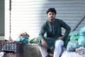 Vertical shot of a Pakistani male with in a market selling fruits in a shalwar kameez