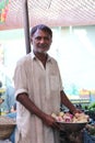 Vertical shot of a Pakistani male with in a market selling fruits in a shalwar kameez