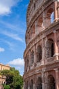 Vertical shot of a part of Colosseum against the blue sky