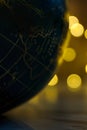 Vertical shot of the part of a globe in the bokeh effect lights background