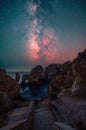 Vertical shot of a pathway to a rocky shore with the Milky Way in the sky in Algarve, Portugal