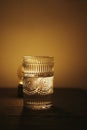 Vertical shot of a patterned glass next to a lamp, artsy aesthetic