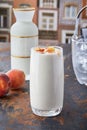 Vertical shot of a peach smoothie in big glass on the table with blur background