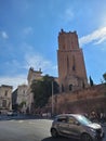 Vertical shot of people and cars in the streets of Rome with the Militia Tower in the background.