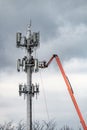 Vertical shot of people on a crane near the Antenna tower Royalty Free Stock Photo