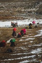 Vertical shot of people paying homage to Mount Kailash and snow on the land in Taqin County, Tibet