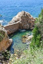 Vertical shot of people practicing paddle surf in a cove on the Costa Brava in Spain