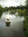 Vertical shot of people riding in white small boats