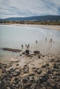 Vertical shot of the people at the rocky beach of Monkey Island enjoying the summer day