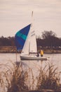 Vertical shot of people on a sailboat on a gloomy morning