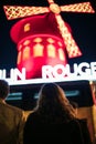 Vertical shot of people standing in front of the Moulin Rouge in Paris, France Royalty Free Stock Photo