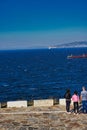 Vertical shot of people standing near the sea in Coruna. Galicia, Spain