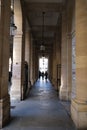 Vertical shot of people under the arches near the columns of Buren, Paris, France