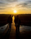 Vertical shot of the people walking on the road at sunrise