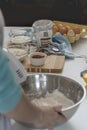 Vertical shot of a person baking a cake with butter, cocoa powd, flour, and eggs