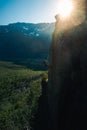 Vertical shot of a person climbing the hill with the beautiful sun rays in the background Royalty Free Stock Photo