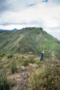 Vertical shot of a person on Colombia mountains path in Bogota with cityscape and cloudy sky