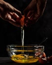 Vertical shot of a person cracking an egg into a glass bowl Royalty Free Stock Photo