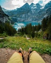 Vertical shot of a person enjoying the view of Oeschinen Lake surrounded by trees and mountains