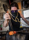 Vertical shot of a person glass blowing in the workshop