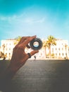 Vertical shot of a person holding a camera lens with a historical concrete building in background Royalty Free Stock Photo