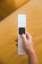 Vertical shot of a person holding a remote control with a blurred background Royalty Free Stock Photo