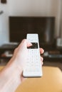 Vertical shot of a person holding a remote control with a blurred background Royalty Free Stock Photo