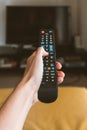 Vertical shot of a person holding a remote control with a blurred background Royalty Free Stock Photo