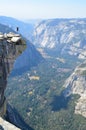 Vertical shot of a person jumping on a cliff at Half Dome, Yosemite, California Royalty Free Stock Photo