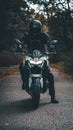 Vertical shot of a person on a Kawasaki Z900 Naked motorbike in the forest