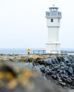 Vertical shot of a person near a white lighthouse