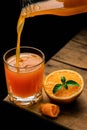Vertical shot of a person pouring fresh orange juice into a glass on the table Royalty Free Stock Photo