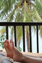 Vertical shot of a person resting their feet on a hammock near the beach Royalty Free Stock Photo