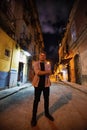 Vertical shot of a person standing in the street in Havana, Cuba captured at night