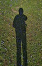 Vertical shot of a person's silhouette in a green field during the day Royalty Free Stock Photo