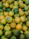Vertical shot of a pile of multicolored green yellow ripe clementines at a market