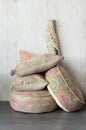 Vertical shot of a pile of soft pillows against a white wall