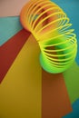 Vertical shot of plastic rainbow magic spring toy against colorful background with copy space Royalty Free Stock Photo
