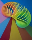 Vertical shot of plastic rainbow magic spring toy against colorful background with copy space Royalty Free Stock Photo