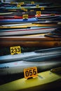 Vertical shot of plenty of colorful kayaks each with a signboard of numbers