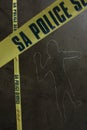 Vertical shot of a police crime scene with body outline chalk drawing